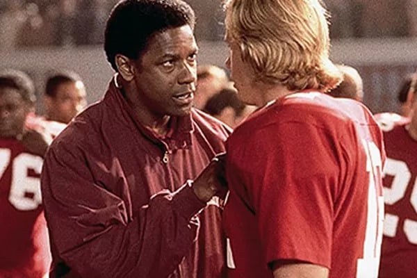 Em cena do filme Duelo de Titãs, personagem interpretado por Denzel Washington encara ator que interpreta jogador de futebol americano