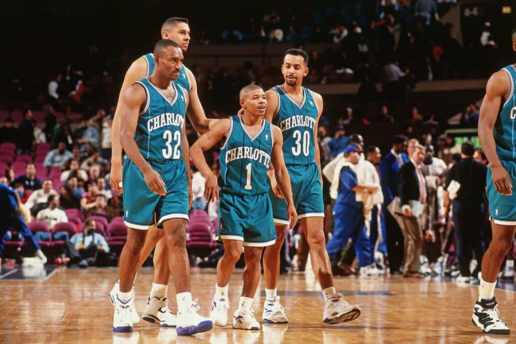 Jogadores do Charlotte, em quadra para jogo da NBA, em 1994. Ao centro, Muggsy Bosses, menor jogador da história da liga.