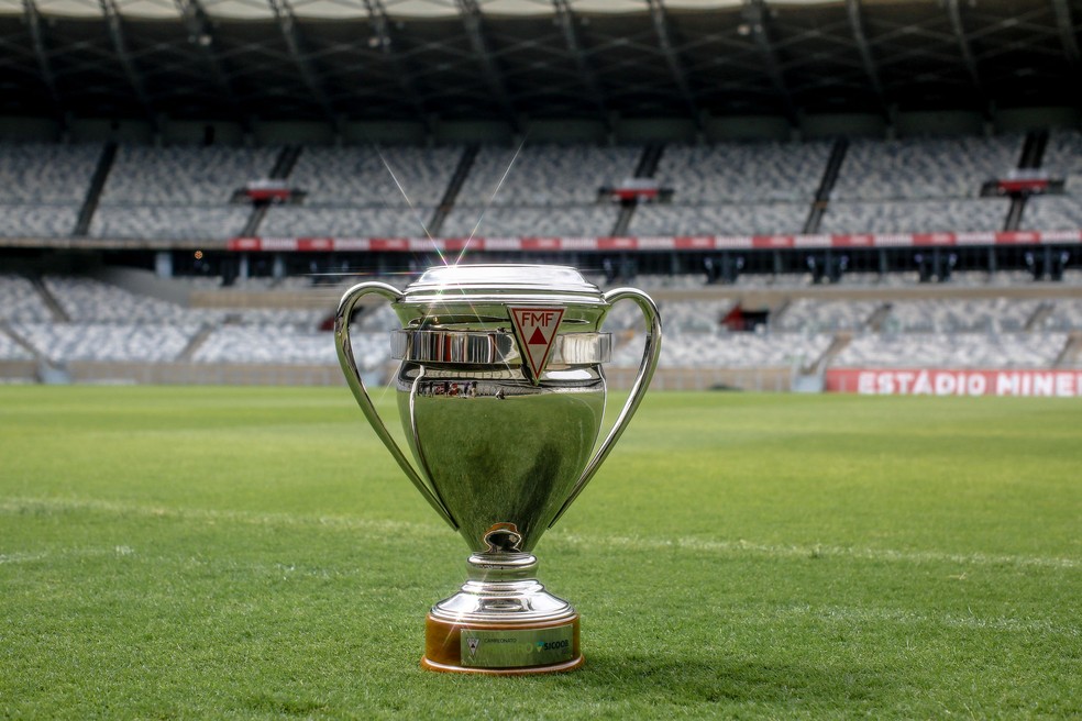 Taça do Campeonato Mineira, posicionada no centro do gramado de um estádio de futebol